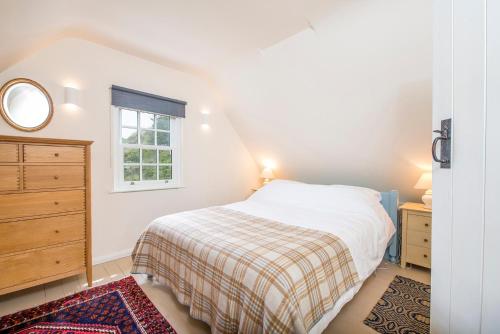 a bedroom with a bed and a dresser and a window at The Nant in Haverfordwest