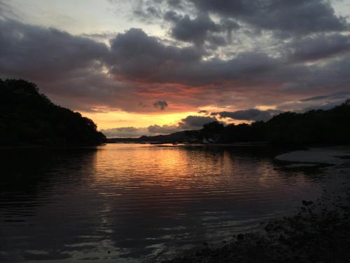 a sunset over a body of water with clouds at Lodge Margouillat in Tambor