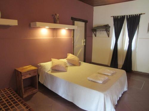 a bedroom with a bed with two pillows on it at YPORA Ldg in Colonia Carlos Pellegrini