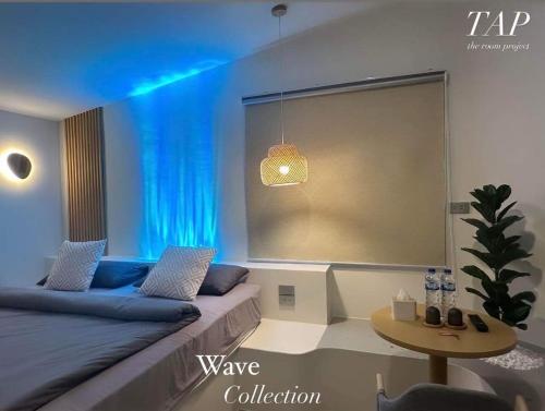 a room with a bed and a table and a window at TAP Salaya in Salaya