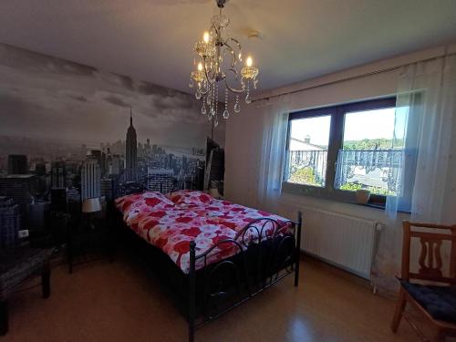 a bedroom with a bed and a window and a chandelier at Adelheids Apartment in Lützelbach