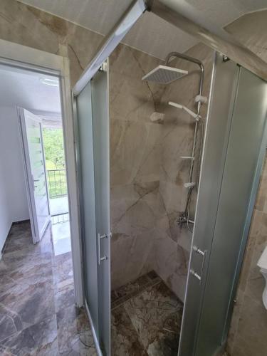 a bathroom with a shower with a glass door at Apartmani Lucica in Jajce