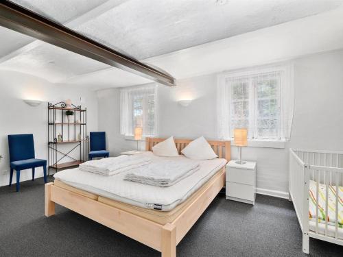 a bedroom with a bed and two blue chairs at Holiday Home Jolanda by Interhome in Bramming