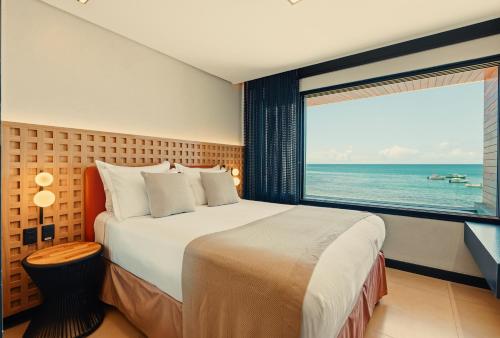 a bedroom with a large bed and a large window at Pousada Antonella in Morro de São Paulo