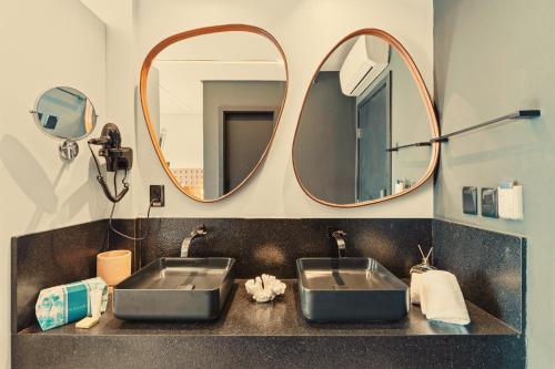 a bathroom with two sinks and a mirror at Pousada Antonella in Morro de São Paulo