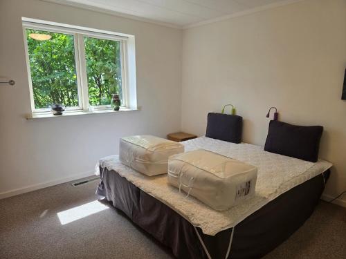 a room with a bed with two bags on it at Spacious foresthouse with stunning view in Ydby