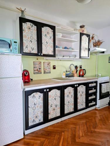 a kitchen with black cabinets and a white refrigerator at Ohrazenice 103 in Turnov