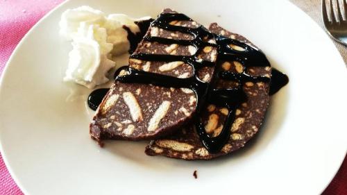 a white plate with chocolate waffles and whipped cream at Albergo Alpino Cheggio in Alpe Cheggio