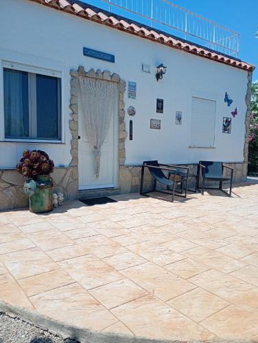 a patio in front of a white building with a door at Finca el Gaudi, casita Catharina in L'Ampolla