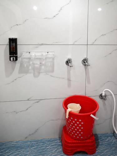 a red bucket in a bathroom with a shower at Tree Heaven Resort-Kanatal in Kanatal
