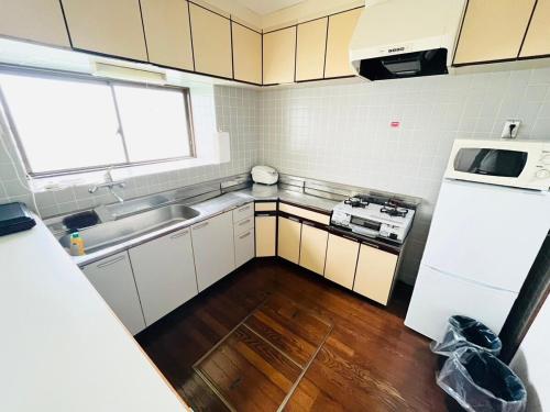 a small kitchen with a sink and a refrigerator at Lemon みやざき in Miyazaki