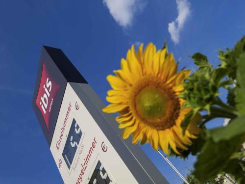 a sunflower is next to a gas station sign at ibis Berlin Dreilinden in Kleinmachnow