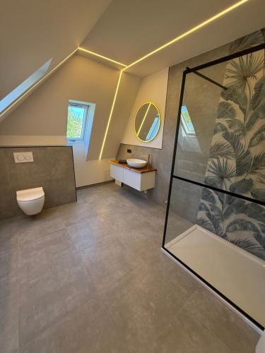 a bathroom with a shower and a toilet and a sink at Pro Home Elia Maisonette in Bad Oeynhausen