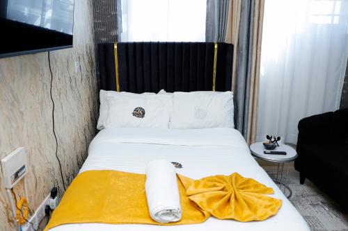 a hotel room with a bed with a yellow blanket at JS Urban Stays in Gatunga
