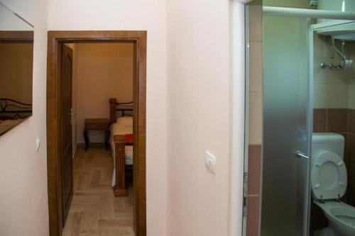 a bathroom with a toilet and a door to a room at Apartments Djurovic with Pool in Dobra Voda