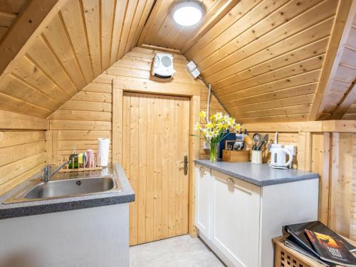 a kitchen with a sink and a wooden ceiling at Chalet Forester's Bothy by Interhome in Coldstone