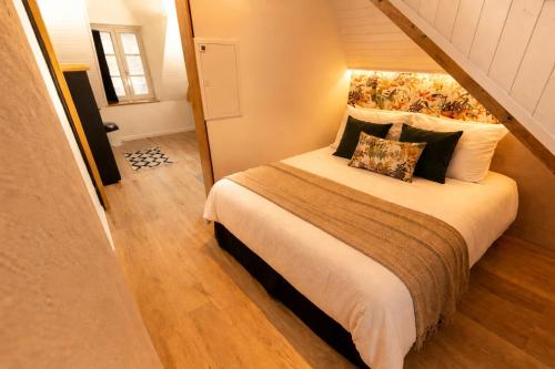 a bedroom with a large bed with pillows at MRODBNB - Appart Neuf - Vue Mer - 25m Plage & Resto - Ciné - cheminée - Popcorn in Cancale