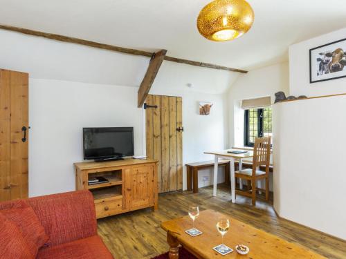 a living room with a couch and a tv and a table at Apartment The Appleloft suite by Interhome in Holsworthy