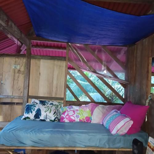 a bed in a room with a blue ceiling at TANGARA Hostel in Buenaventura