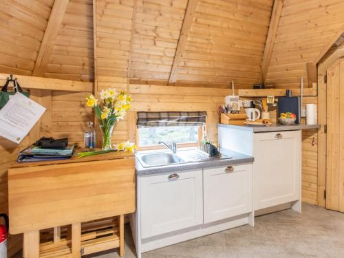 a kitchen with a sink in a wooden cabin at Chalet Beekeepers Bothy by Interhome in Coldstone