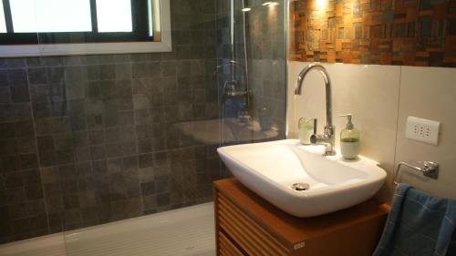 a bathroom with a sink and a shower and a tub at Das Glashaus in Curacautín