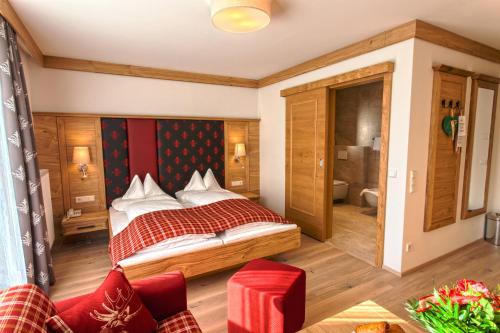 a bedroom with a bed and a bathroom at Hotel Zum Stern inkl Gasteiner Bergbahnen im Sommer in Bad Hofgastein