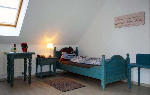 ein kleines Schlafzimmer mit einem Bett und zwei Tischen in der Unterkunft Pension Finkenschenke in Gröditz