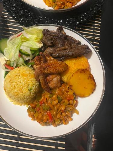 a plate of food with meat and vegetables and rice at EcoGreen Bed&Breakfast in Northam