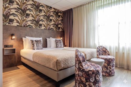 a hotel room with a bed and a chair at Hotel Wander in Wageningen