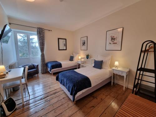 a bedroom with two beds and a desk and a chair at Le Rodin Bazas in Bazas