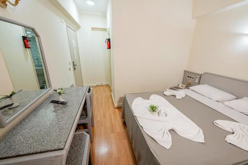 a room with two beds and a sink and a mirror at Emilio Hotel in Luxor