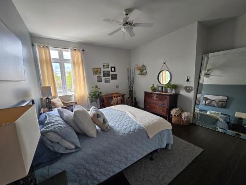 a bedroom with a bed and a ceiling fan at Shediac Beach Suite- Pointe du Chene Wharf and Parlee Beach in Pointe-du-Chêne