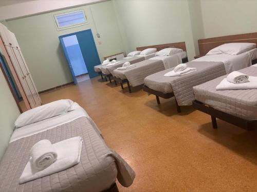 a row of beds in a room with a blue door at Campus Baia Serena in Bellaria-Igea Marina