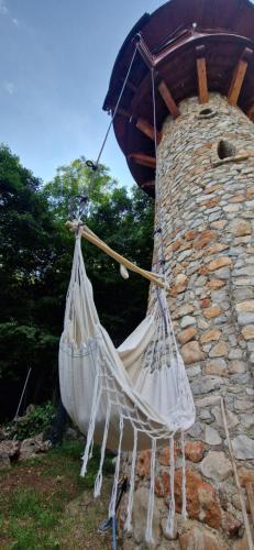 a hammock is hanging next to a stone building at Veža na vlásku in Háj