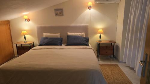 a bedroom with a large bed with two lamps on two tables at Vilas do Mar - Studio in Carvoeiro