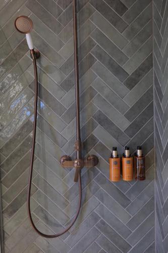 a shower with a shower head in a bathroom at The Spot Resort in Poljanski Lug