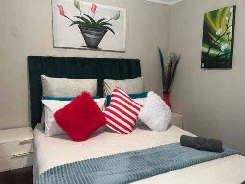 a bed with colorful pillows on top of it at EcoGreen Bed&Breakfast in Northam