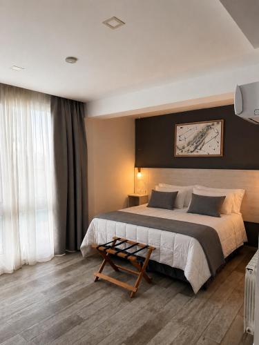 a bedroom with a large bed and a table at La Olivia Hotel Boutique & Spa in La Falda