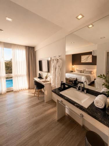 a large bathroom with a bed and a large mirror at La Olivia Hotel Boutique & Spa in La Falda