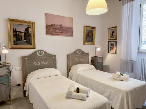a room with three beds with towels on them at Casa Mariarosa in Volterra