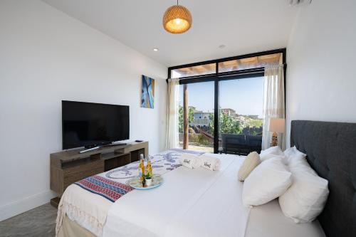 a bedroom with a large white bed and a television at Casa Arte by Vibrant in Vichayito