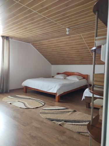 a bedroom with a bed and a wooden ceiling at casa Olga 2 Mai in 2 Mai