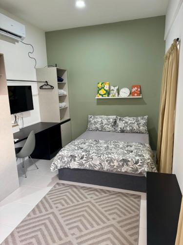 a small bedroom with a bed and a desk at Studio Inap Seri Iskandar in Kampong Bota Road