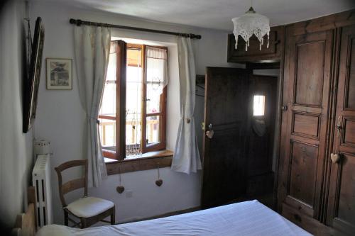 une chambre avec un lit, une fenêtre et une chaise dans l'établissement chez Annie & Marcel, au Monêtier-les-Bains