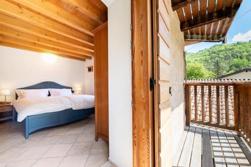 ein Schlafzimmer mit Bett und Balkon in der Unterkunft B&B Arlanch 8 in Vallarsa