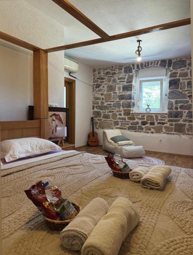 a bedroom with a large bed with a stone wall at Villa with stunning Mountain Views and Authentic Croatian Stone House near Split and Sea in Žrnovnica