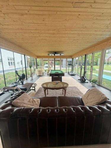 a living room with a leather couch and a table at Berckenhof in Heusden - Zolder