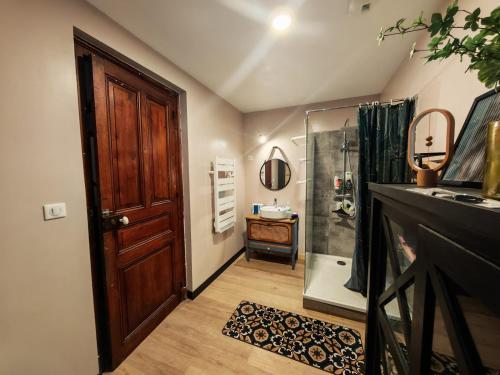 a bathroom with a shower and a wooden door at Chez Mina in Saint-Béat
