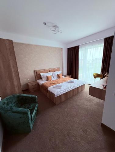 a hotel room with a bed and a chair at Alemar Mamaia Nord in Năvodari