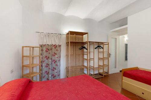 a bedroom with a red bed and some shelves at Casa Lena in Arma di Taggia